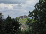 SX16176 Carreg Cennen Castle on top of distant cliffs seen through trees.jpg